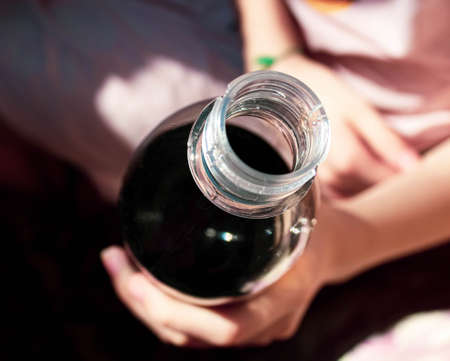 A plastic bottle with a carbonated drink in your hand. Selective focus, top view.の写真素材