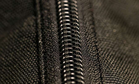 Macro photography of a closed black lightning lock. Close-up, selective focus.