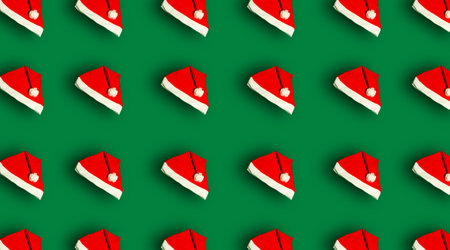 Christmas pattern with a Santa Claus hat on a green background. Prints and patterns.の写真素材