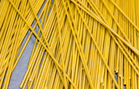 Long thin spaghetti is scattered on the table. Close-up.の写真素材