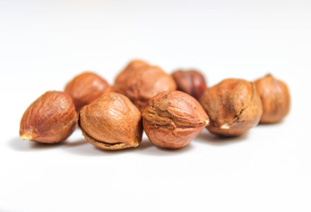 Several hazelnuts without shells close-up on a white background. Selective shot.