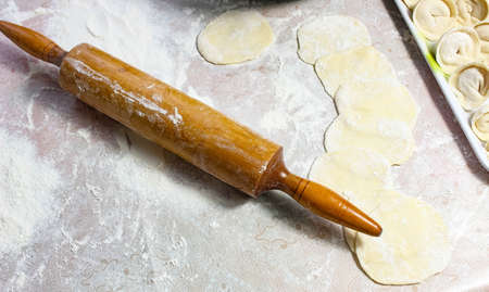 Wooden rolling pin on the table with flour and dough. Top view.の写真素材