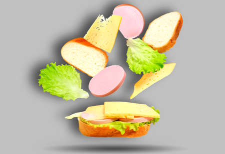A sandwich with the ingredients that make up it falling on it. Flying the recipe, levitation. Making...