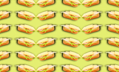 A pattern of sandwiches with sausage, cheese and salad on a green background. Grocery background. Prints, patterns, copy space.の写真素材