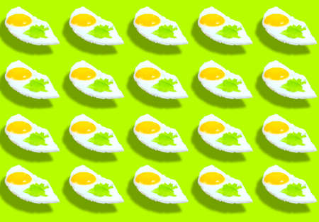 A pattern of fried eggs with lettuce leaves on a green background. Product space. Prints,...