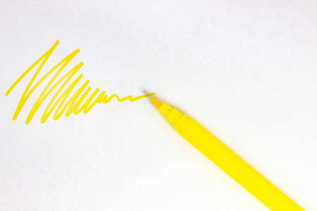 A yellow stroke on white paper from a felt-tip pen. Top view.の写真素材
