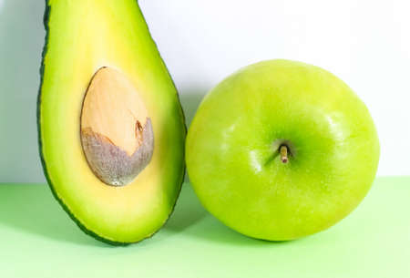 Half an avocado and a whole green apple close-up. Selective focus.の写真素材