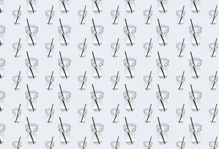 A pattern with clear water in a glass with a drinking straw on a gray background. The concept of...