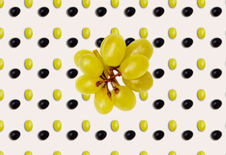 A pattern with black and green grapes in the background and a bunch of green grapes in the middle. Templates, prints.の写真素材