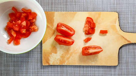 Sliced slices of ripe tomato for salad on a cutting board. top view.