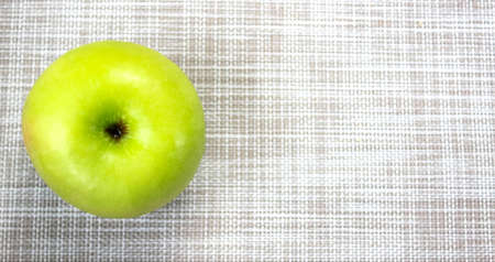 One whole green apple, the concept of healthy proper nutrition. Top view, horizontal frame, space for text.の写真素材