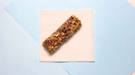One whole energy bar on a paper napkin. The concept of sports nutrition. Top view.の写真素材