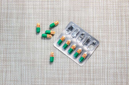The medicine capsules in the blister are moved on the table. Pills, vitamins. Top view.