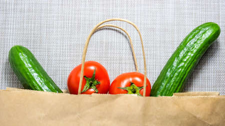 Tomatoes and cucumbers, which are put in a paper bag for shopping. Top view.の写真素材