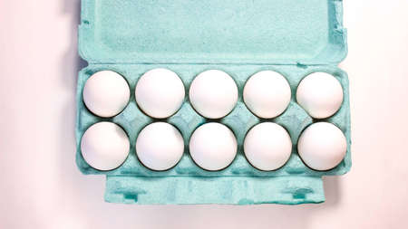 Eco-friendly cardboard packaging with white raw eggs. Top view.
