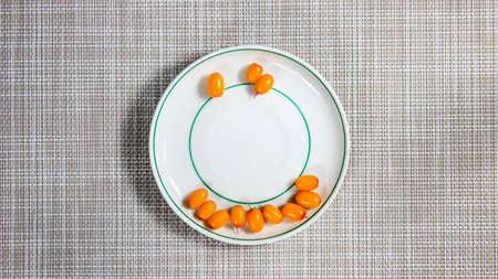 A few sea buckthorn berries on a saucer. ripe holy fruits. Top view.の写真素材