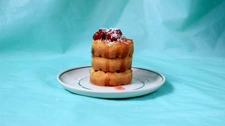 Soft waffles on a saucer, poured with strawberry jam with berries and sprinkled with coconut...
