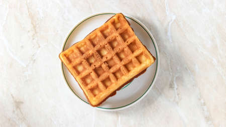 Soft rectangular Viennese waffles on a saucer. Delicious dessert. Top view.の写真素材