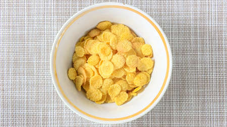 Dry Corn flakes are poured in a plate. A healthy breakfast. Top view.の写真素材
