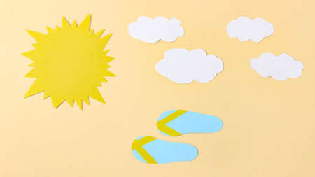 Paper sun and clouds, beach flip-flops run nearby. Summer cartoon. Top view.の写真素材