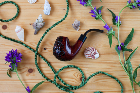 The theme of the sea. Congratulations on the day of the seafarer. Smoking pipe, seashells and...