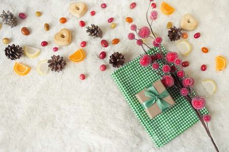 Christmas composition with gift box decorated green ribbon. Still life with sweets, colorful candy and cones. Top viewの写真素材