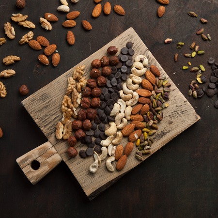 Assorted mixed nuts and chocolate on wooden backgroundの写真素材