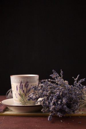 Lavender with cup of tea and cake on the black backgroundの写真素材