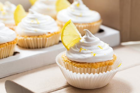 Lemon cupcakes with white cream, cupcake packaging, delivery box, selective focus, close upの写真素材