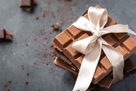 Chocolate bars with beige bow on a grayの写真素材