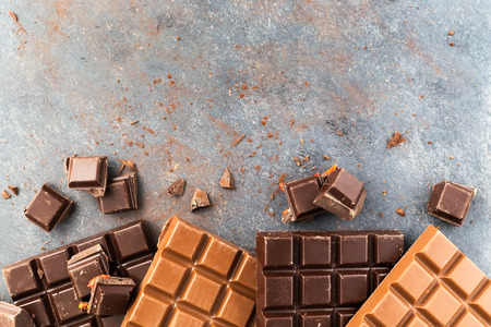 Milk and dark chocolate bars on a gray table. Top viewの写真素材
