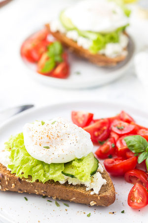 Sandwich with cheese cream, lettuce, poached egg and cherry tomatoes. Healthy foodの写真素材