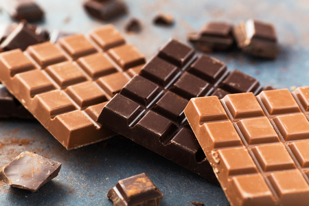 Milk and dark chocolate bars on a gray tableの写真素材