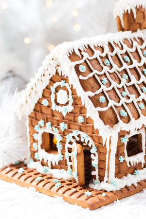 Homemade gingerbread house, white Christmas tree and garland light.の写真素材