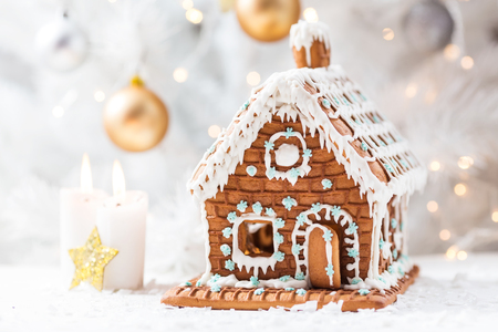 Homemade gingerbread house, white Christmas tree and garland light.の写真素材