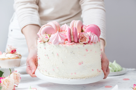 White cake with roses and roses on a tableの写真素材