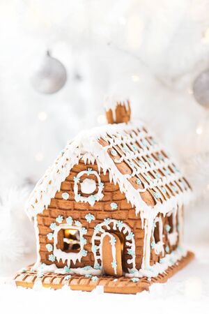 Homemade gingerbread house, white Christmas tree and garland light.の写真素材