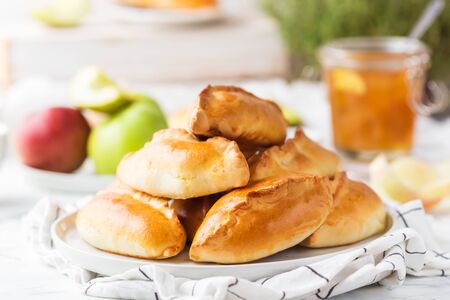 Traditional Russian pastries filled with apples on a white plateの写真素材