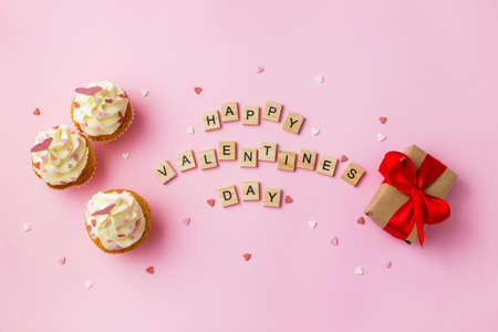 Happy Valentine's Day greeting card. Cupcakes and gift box on pink background.の写真素材