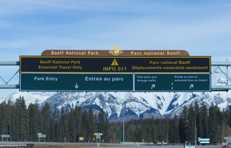 Alberta, Canada - April 20,2020: View of directional board at the entrance of Banff National Park on Trans-Canada Highway. Essential travel only.のeditorial素材