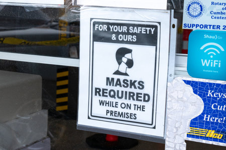 Courtenay, Vancouver Island, Canada - November 21,2020: View of sign Mask Required at the entrance of Store due to COVID-19 Prevention. Pandemic Building Status.のeditorial素材
