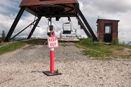 View of sign Keep out near older double chairlifts at Seymour Mountain during the summer season