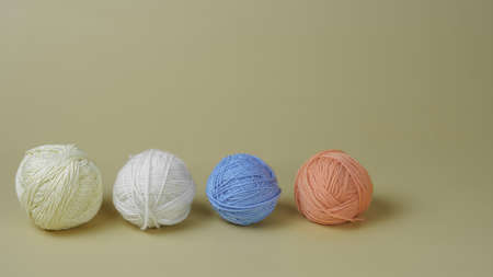 photos of multi-colored threads for knitting lie on a beige background close-up. copy space