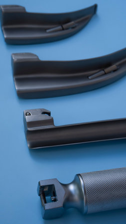 set for intubation of the trachea: blades for a laryngoscope of different sizes lie on a blue...