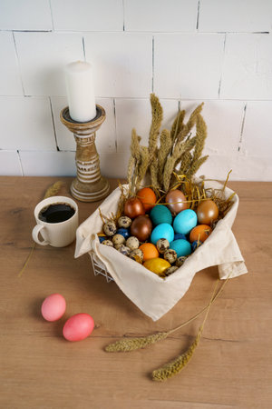 preparation for Easter holiday. fresh colored chicken eggs lie in a deep bowl on the table in the...