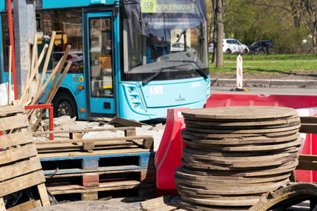 There is an urban construction site with a bus and various materials for work presentのeditorial素材