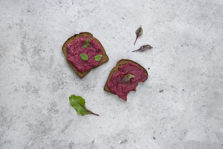 Beetroot Spread on Dark Bread, garnished with Fresh Greens for a wholesome biteの写真素材