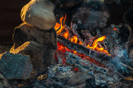 Fireplace made of stones with hot, glowing logsの写真素材