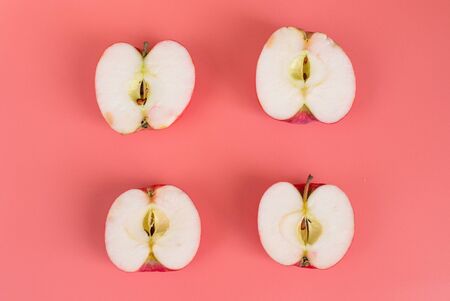 Ripe Apple halves on pink background. Healthy food concept.の写真素材