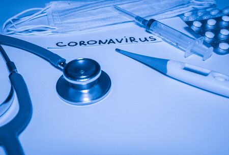 Novel coronavirus-2019-nCoV. Medical blue background with inscription coronavirus, stethoscope, pills, thermometer, syringe. Chinese outbreak coronavirus.の写真素材